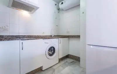 a white laundry room with a washer and dryer at Luminoso y acogedor apartamento en el centro in El Puerto de Santa María