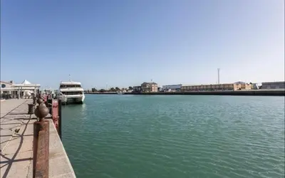 a boat is docked at a dock in the water at Luminoso y acogedor apartamento en el centro in El Puerto de Santa María