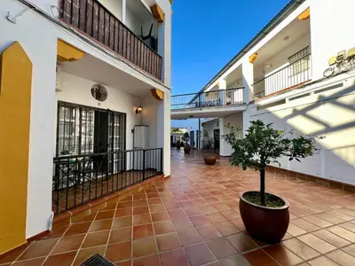 a courtyard of a building with a potted tree at Apartamento Pescadores in Chiclana de la Frontera