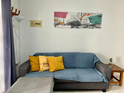 a blue couch with yellow pillows in a living room at Apartamento Pescadores in Chiclana de la Frontera
