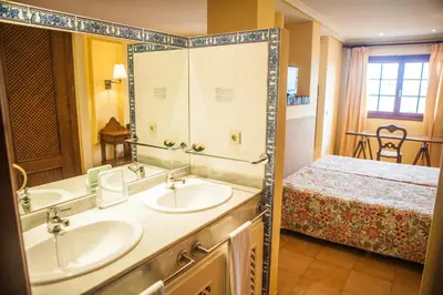 a bathroom with two sinks and a bed at Estudios Turísticos Bahia Sur in San Fernando