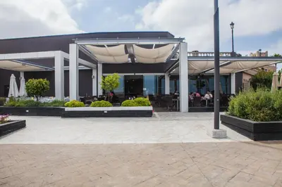 a building with a patio with tables and chairs at Estudios Turísticos Bahia Sur in San Fernando