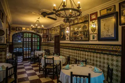 a restaurant with tables and chairs and a chandelier at Estudios Turísticos Bahia Sur in San Fernando