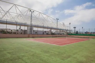 a tennis court in front of a building at Estudios Turísticos Bahia Sur in San Fernando