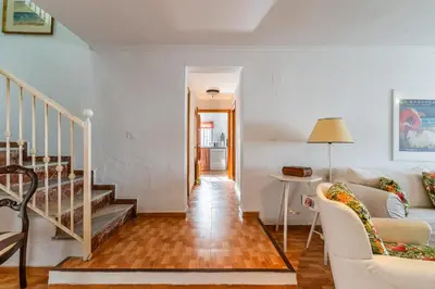 a living room with a staircase and a couch at La Casona in Chiclana de la Frontera