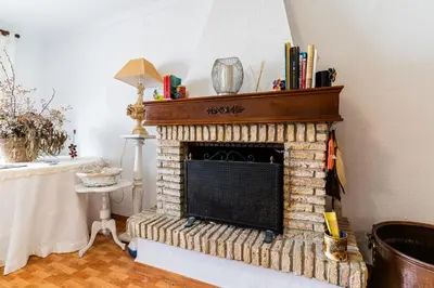 a living room with a brick fireplace with a mantle at La Casona in Chiclana de la Frontera