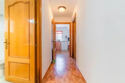 a hallway with a wooden door and a hallwayngth at La Casona in Chiclana de la Frontera