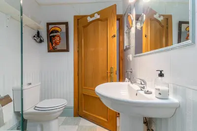 a bathroom with a sink and a toilet and a mirror at La Casona in Chiclana de la Frontera