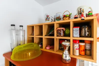 a kitchen counter with a wooden shelf with food items at La Casona in Chiclana de la Frontera