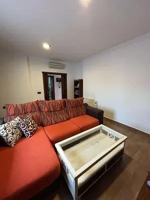 a living room with a red couch with a glass table at Sun and relaxation Book your paradise in Chiclana de la Frontera