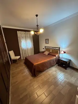 a bedroom with a bed and a table and a chair at Sun and relaxation Book your paradise in Chiclana de la Frontera