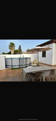 a patio with an umbrella and a table and chairs at Sun and relaxation Book your paradise in Chiclana de la Frontera