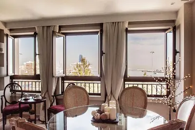 a living room with a table and chairs and windows at Apartamento Vistabella in Cádiz