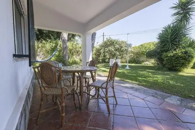 a patio with a table and chairs on a porch at Las Camelias in Chiclana de la Frontera