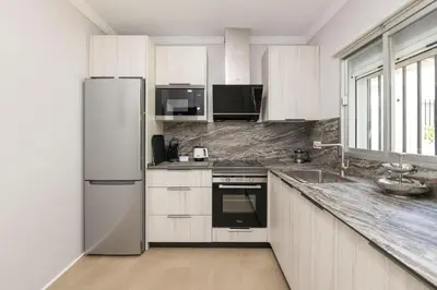 a white kitchen with a refrigerator and a sink at Las Camelias in Chiclana de la Frontera