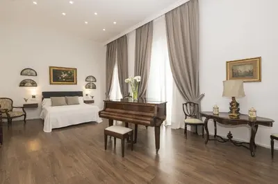 a bedroom with a piano and a bed and a desk at Luxe Madre de Dios in Sanlúcar de Barrameda