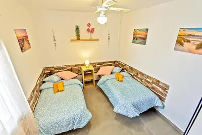 two beds in a room with a table at Plaza España 3-bedroom central & bello apartamento in El Puerto de Santa María
