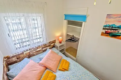a bedroom with a bed with pillows and a window at Plaza España 3-bedroom central & bello apartamento in El Puerto de Santa María