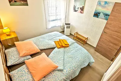 two beds in a room with orange towels on them at Plaza España 3-bedroom central & bello apartamento in El Puerto de Santa María