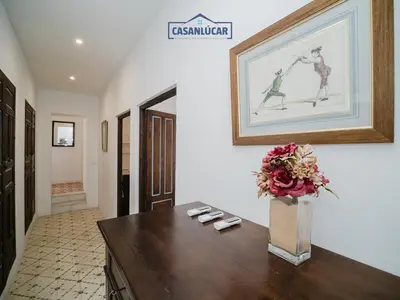 a vase with flowers on a table in a hallway at Casa Puerto Lucero in Sanlúcar de Barrameda