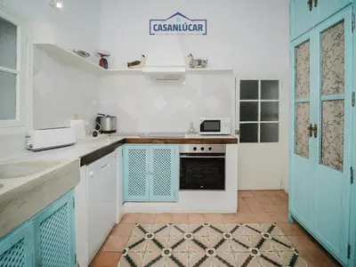 a kitchen with blue and white cabinets and a stove at Casa Puerto Lucero in Sanlúcar de Barrameda