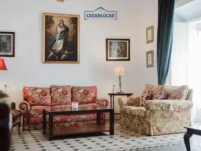 a living room with a couch and a chair at Casa Puerto Lucero in Sanlúcar de Barrameda