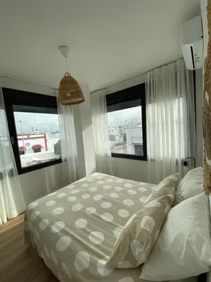 a bed in a bedroom with two windows at Casa Mateo in Jedula