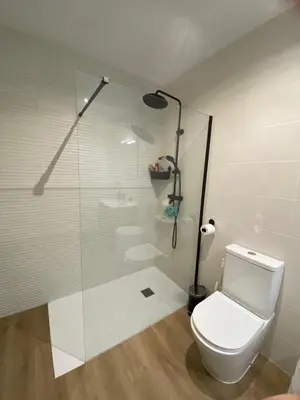 a bathroom with a toilet and a glass shower at Casa Mateo in Jedula