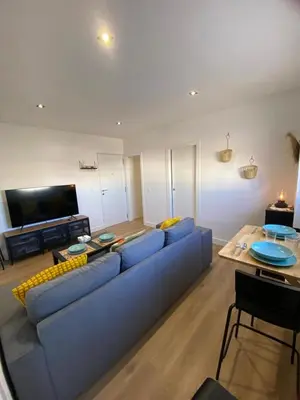 a living room with a blue couch and a tv at Casa Mateo in Jedula