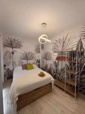 a bedroom with a bed with plants on the wall at Estudio en Jerez de la Frontera in Jerez de la Frontera