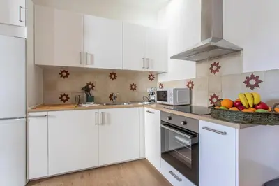 a kitchen with white cabinets and a bowl of fruit at Taina La Merced Suite in Jerez de la Frontera