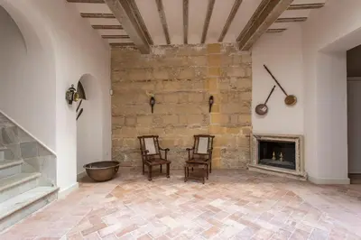 a living room with two chairs and a fireplace at Taina La Merced Suite in Jerez de la Frontera