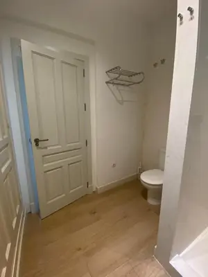 a bathroom with a toilet and a white door at Taina La Merced Suite in Jerez de la Frontera