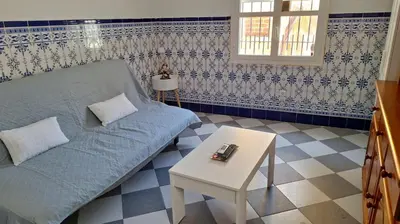 a living room with a blue couch and a table at La Marea in Chipiona