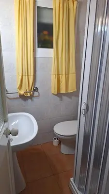a bathroom with a sink and a toilet and a window at La Marea in Chipiona