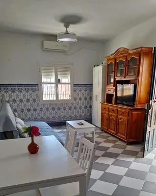 a living room with a table and a refrigerator at La Marea in Chipiona