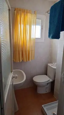 a bathroom with a toilet and a sink and a window at La Marea in Chipiona
