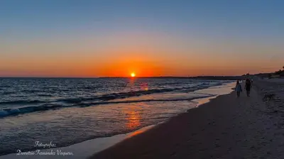 a group of people walking on the beach at sunset at Casa Ianira in El Puerto de Santa María