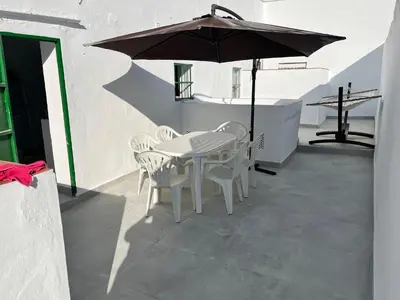 a table and chairs with an umbrella on a patio at Casa Ianira in El Puerto de Santa María