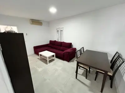 a living room with a red couch and a table at Casa Ianira in El Puerto de Santa María