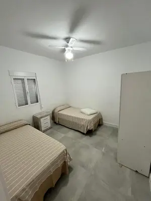 a room with two beds and a ceiling fan at Casa Ianira in El Puerto de Santa María