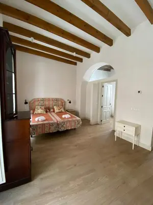 a living room with a bed and a table at Taina Suite La Merced Primero Muro in Jerez de la Frontera