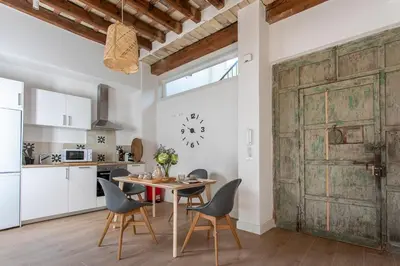 an old barn door in a kitchen with a table and chairs at Taina Suite La Merced Primero Muro in Jerez de la Frontera