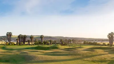 a view of a golf course with palm trees at Taina Suite La Merced Primero Muro in Jerez de la Frontera