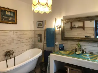a bathroom with a tub and a sink and a mirror at Mediterranean house in Bajo Guía in Sanlúcar de Barrameda