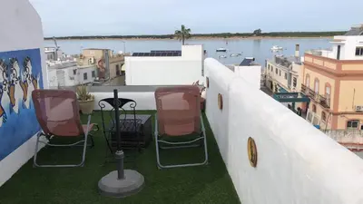 a balcony with chairs and a view of the water at Mediterranean house in Bajo Guía in Sanlúcar de Barrameda
