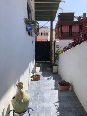 a narrow alley with a vase on the side of a building at Mediterranean house in Bajo Guía in Sanlúcar de Barrameda