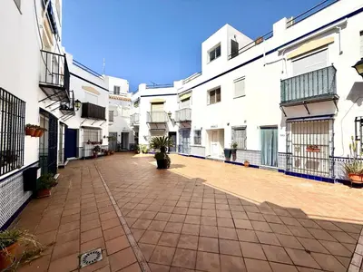 an empty courtyard of a building with white buildings at Sousa by Staycare in Chipiona