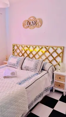 a bedroom with a bed with a love sign on the wall at Casa Nieves, totalmente equipada Planta 2 in Arcos de la Frontera