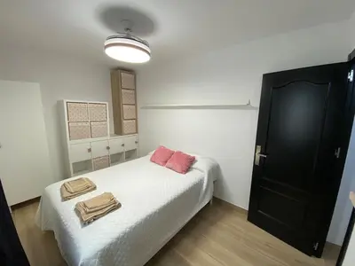 a bedroom with a bed with two towels on it at Apartmento Carmen Viejo, Centro in Sanlúcar de Barrameda